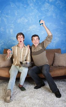 Excited young Caucasian man with friend watch television