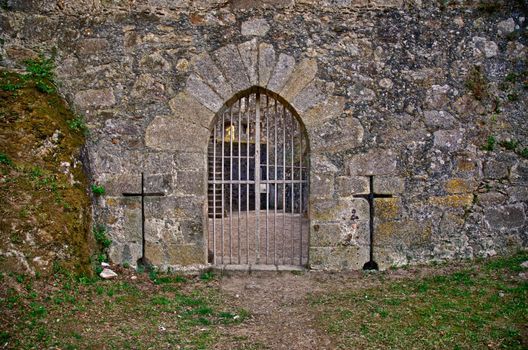 Old medieval castle gate in a fortified granite wall.