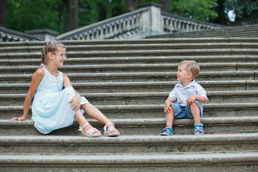 Brother and sister outdoors in city on beautiful summer day