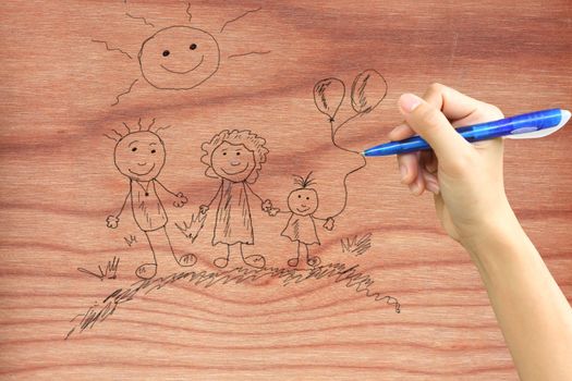 Hand drawing a happy family on wood