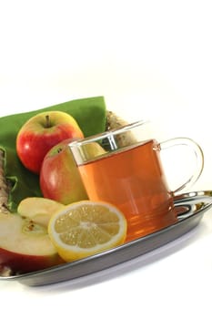 a glass of apple-lemon tea with fresh apple and lemon