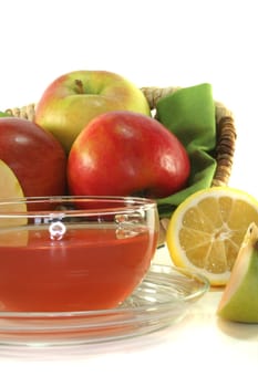 a glass of apple-lemon tea with fresh apple and lemon