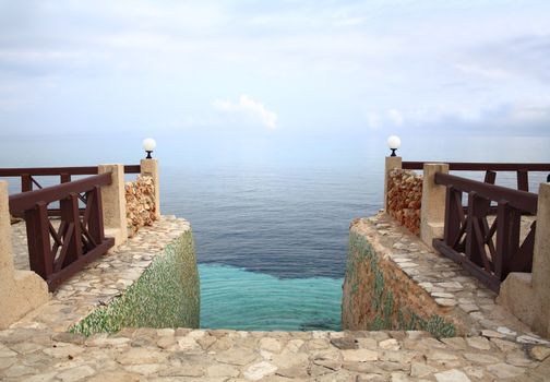 Steps leading into the Caribbean Sea, merging with the sky, at dusk.