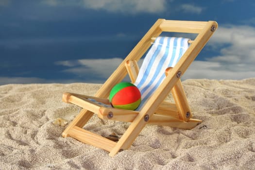 Deck chair and a water polo on a sandy beach