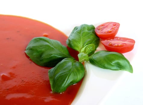a plate of tomato soup with fresh basil