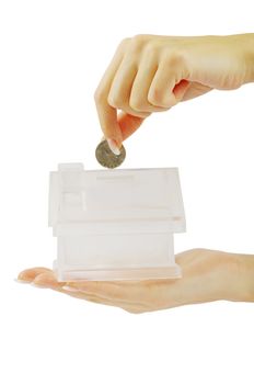 Hand with coin and house bank isolated on white background