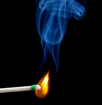 Green coated match head starts to burn with light blue smoke