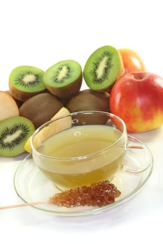 a glass of kiwi-apple tea with fresh kiwis, apples and candy