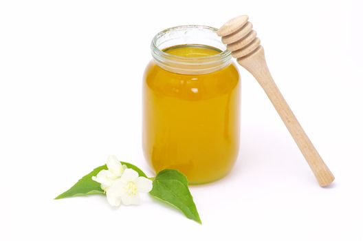 glass pot full of honey and stick isolated on white background
