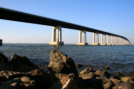 Long modern bridge built over a river.
