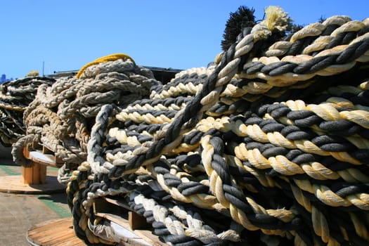 Row of ship yard ropes over blue sky.
