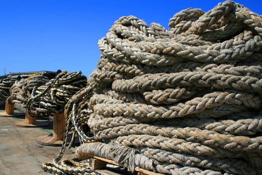 Row of ship yard ropes over blue sky.
