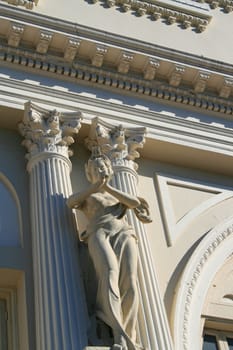 Statue next to columns showing unique architecture of a building.