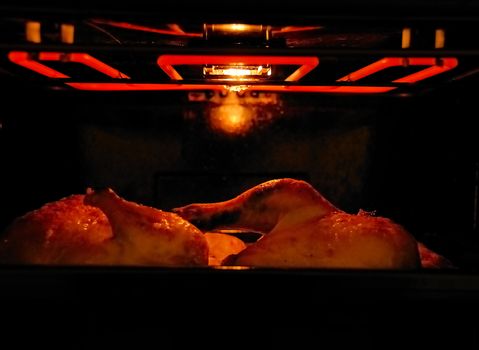 Hot chicken in electric oven / grill. Selective focus. Norway.