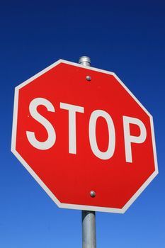 Stop road sign over clear blue sky.
