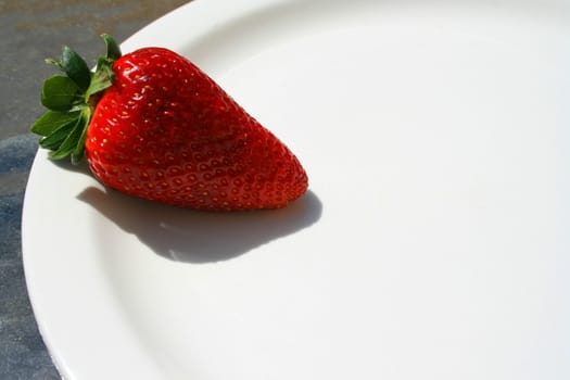 Close up of a strawberry on a plate.
