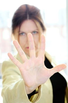 Mature woman gesturing stop with palm of her hand
