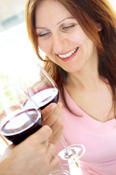 Smiling mature woman toasting with a glass of red wine