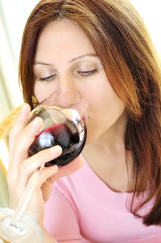 Mature woman drinking from a glass of red wine