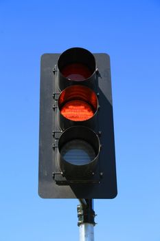 Close up of a traffic light showing amber light.
