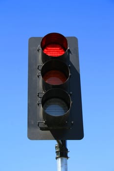 Close up of a traffic light showing red light.
