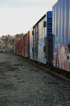 A row of train containers in a train yard.