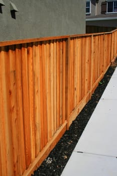 Wooden yard fence next to a house.
