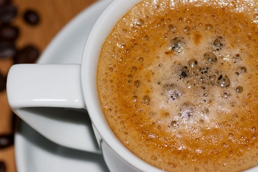 A close up of a cup of frothy espresso coffee