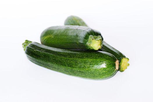 Three green ripe courgettes