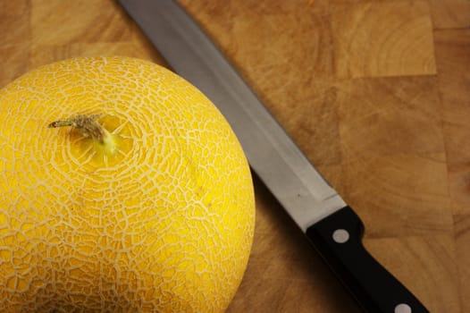 A ripe galia melon with a sharp knife ready to cut and eat