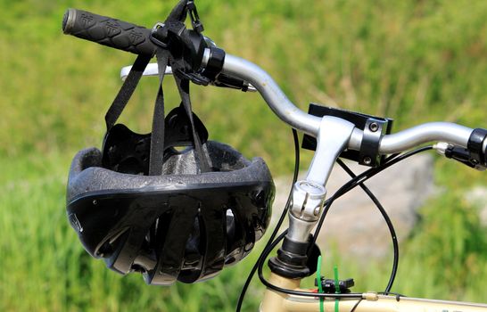 Bike helmet hanging on bicycle handle bar