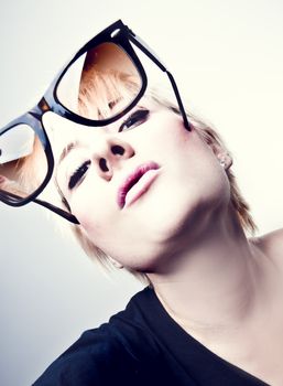 Portrait of a young, blonde girl with short hair and sunglasses