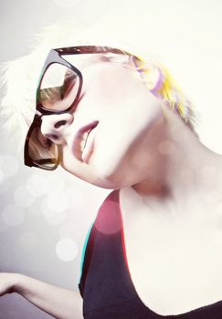 Portrait of a young, blonde girl with short hair and sunglasses