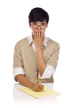 Shocked Mixed Race Young Adult Female Student at Table with Pad of Paper and Pencil Isolated on a White Background.