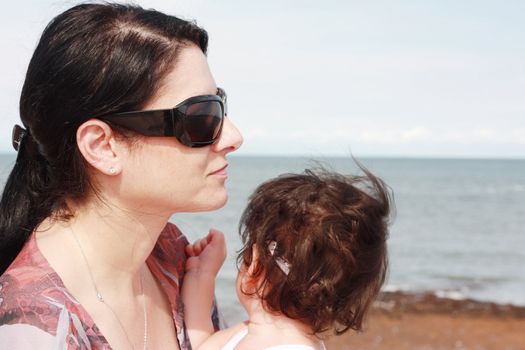Mother and daughter enjoy hot summer weather at the beach.