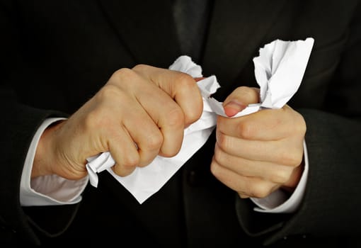 Businessman hands furiously tormenting document close up