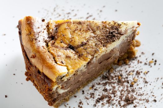 Slice of chocolate cheesecake sprinkled with chocolate flakes.