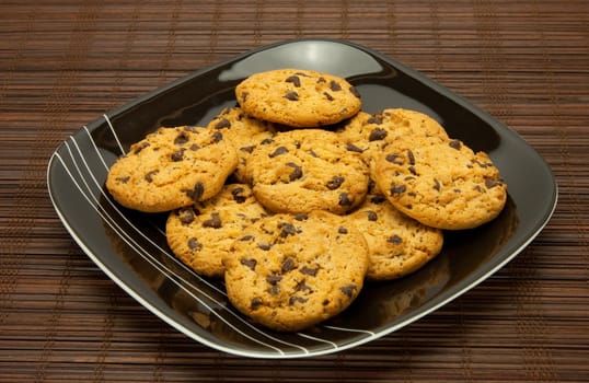A plate of cookies on dark brown background