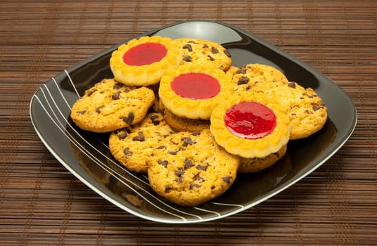 A plate of cookies on dark brown background