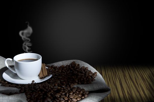 cup of coffee and coffee beans on the Sacking, abstract grunge background