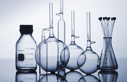 Scientific laboratory glass conical Erlenmeyer flasks with scientific cylinders and beakers assorted glassware for a chemistry experiment in a science research lab