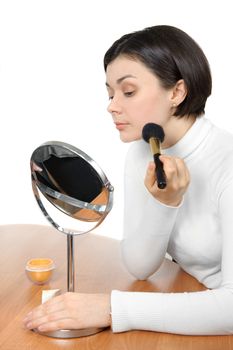 young brown eyed lady applying powder using soft brush