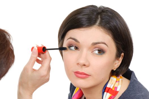 young brown eyed lady applying mascara using lash brush