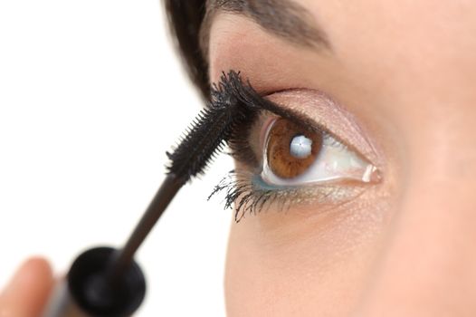 young brown eyed lady applying mascara using lash brush