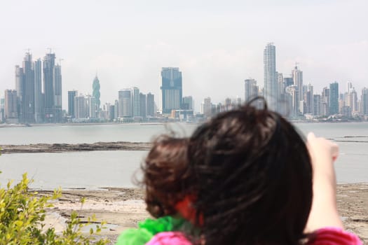 Mother shows her daughter a beautiful view over the city