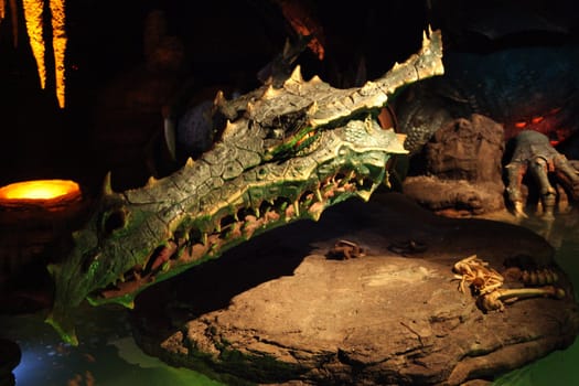 A Dragon in a cave laying on a rock