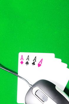 An online gaming concept with computer mouse, four aces and green felt