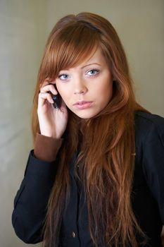 Teenage girl using mobile phone, looking at camera