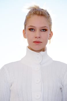 Teenage girl portrait, backlit exterior against sky