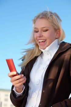 Teenage girl looking at mobile phone, laughing